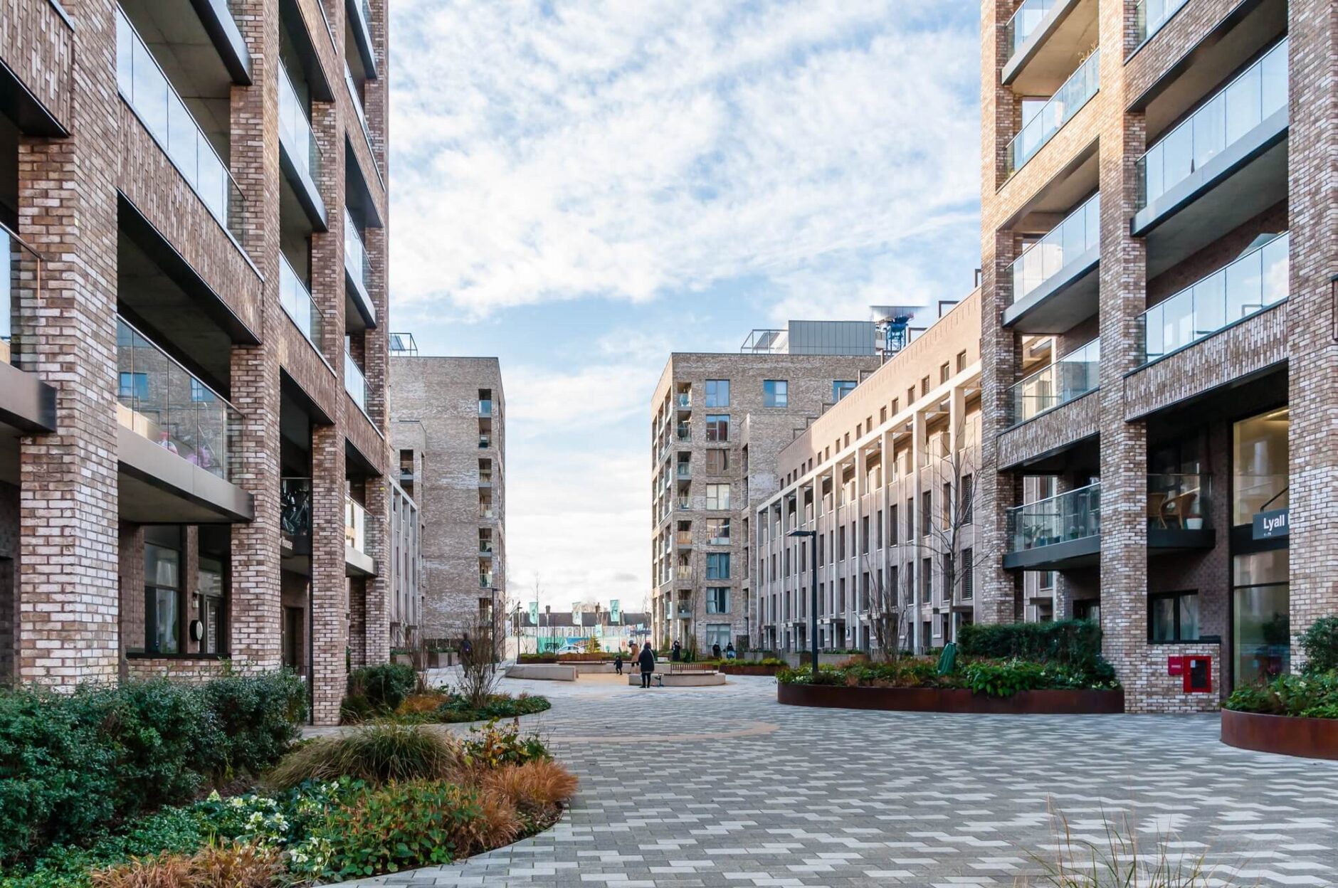 Modern apartment complex with pedestrian walkway and landscaping.